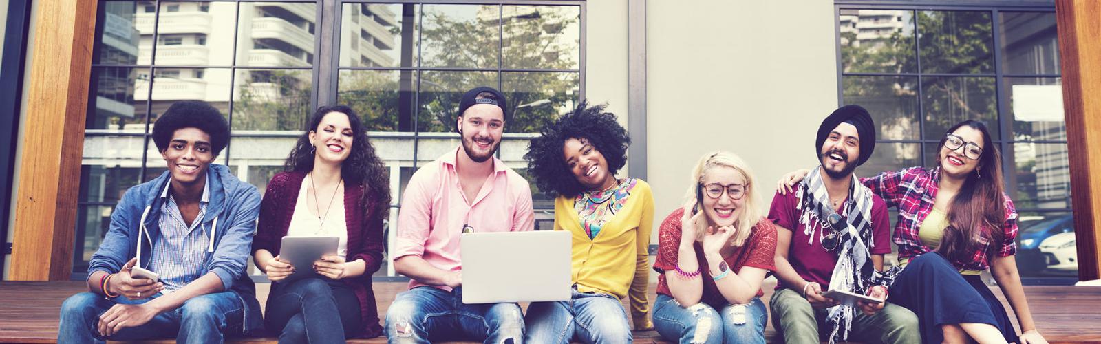 group of diverse students sitting outside